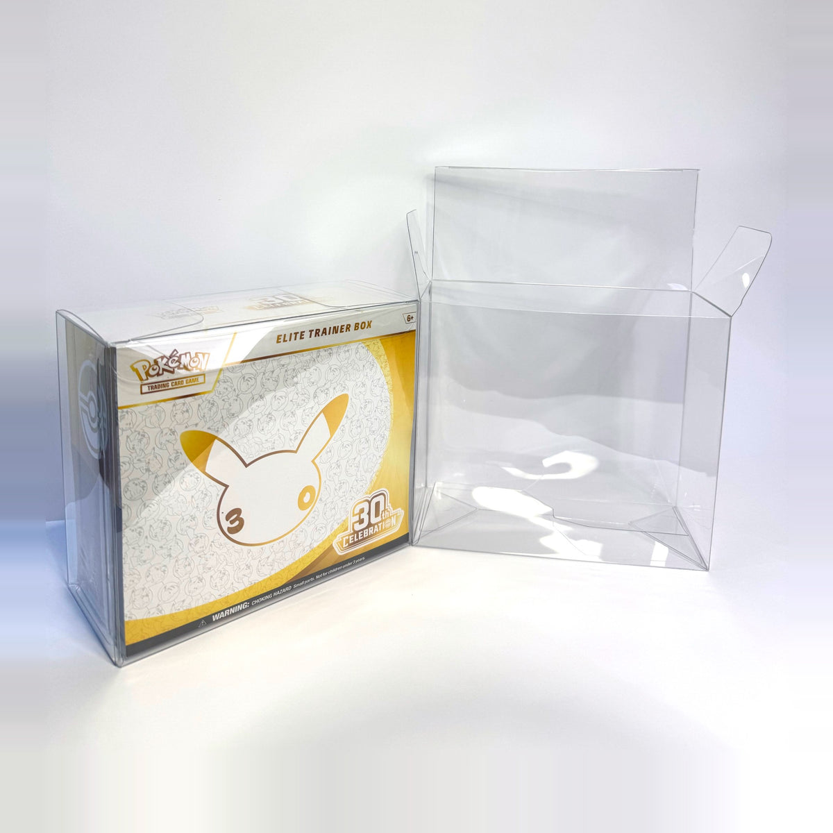Celebrations Elite Trainer Box in a clear Sealed Armor protector next to an empty protector